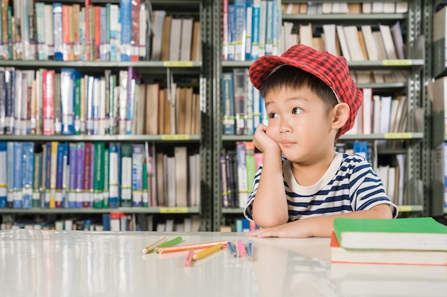 Ragazzo asiatico nella scuola della stanza della biblioteca