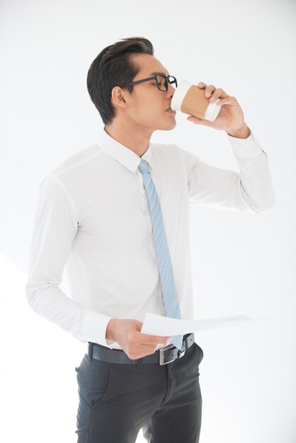 Asian Business Man Drinking and Holding Document