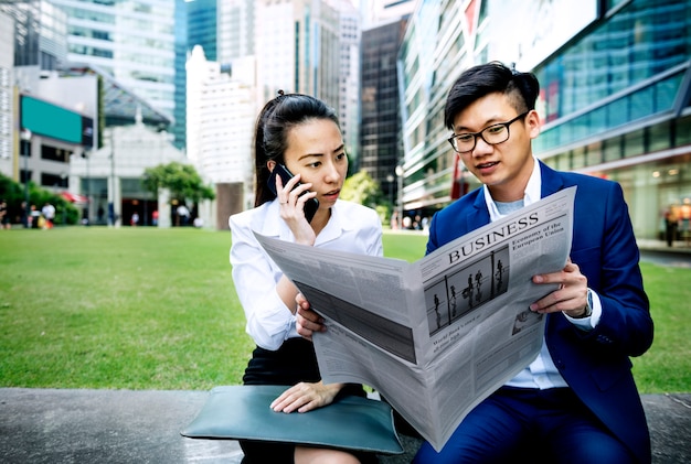 Free photo asian business people reading the newspaper