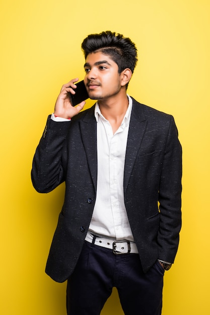 Asian businessman handsome man wi talk on smart phone on yellow wall