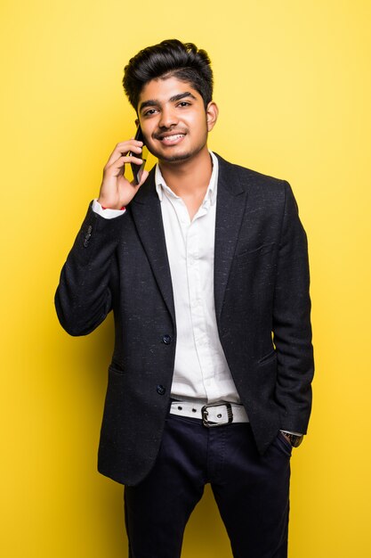 Asian businessman handsome man wi talk on smart phone on yellow wall