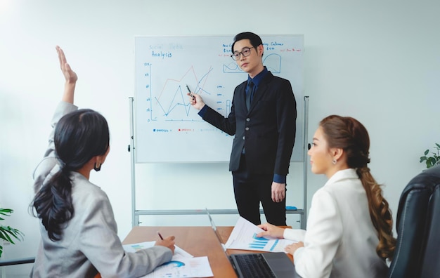 Foto gratuita uomo d'affari asiatico che presenta il suo lavoro ai colleghi aziendali durante una riunione in ufficio