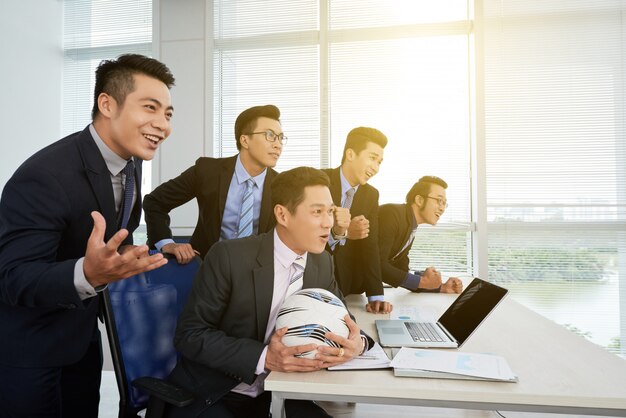 Free photo asian businessman watching football match