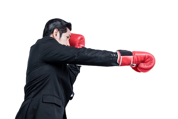 Азиатский бизнесмен с красными боксерскими перчатками борется изолированно над белой стеной