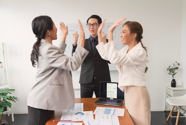 会社の成功についての会議中のアジアのビジネスマンのお祝い