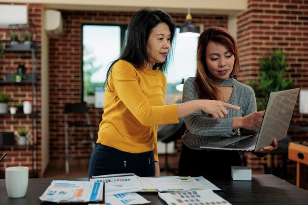 아시아 여성 사업가는 시작 사무실에서 비즈니스 회의 중에 회사 수익을 높이기 위해 관리자와 협력합니다. 경영 전략 기획 사업 제휴에서 일하는 아시아 경제인