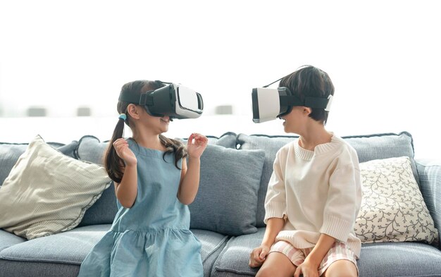 집에서 가상 현실 메타버스를 위해 360 VR 헤드셋을 사용하는 동안 흥분을 느끼는 아시아 어린이