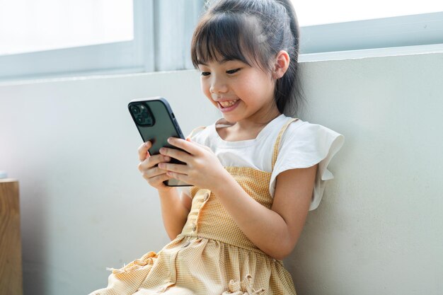 Asian child using smartphone at home