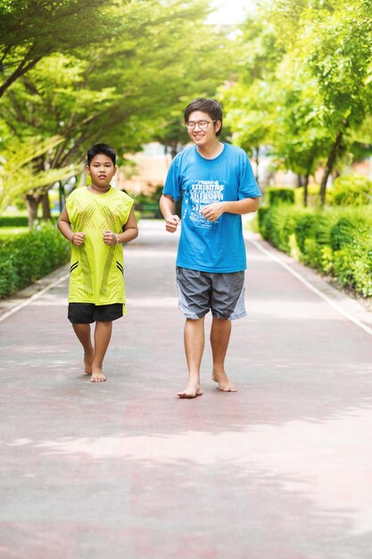 兄弟のアジア人カップルが公園で一緒に走る