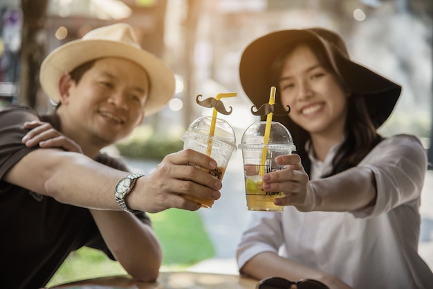 Asian couple enjoy traveling sitting at coffee shop 