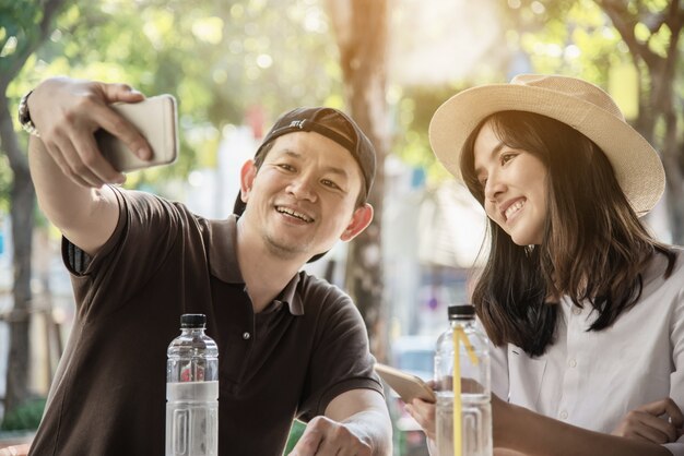 아시아 부부는 커피 숍에 앉아 여행을 즐길 수