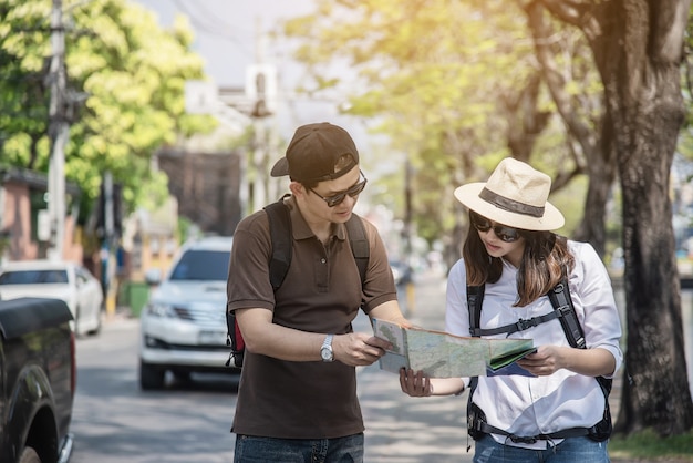 Foto gratuita mappa turistica della città della tenuta turistica delle coppie asiatiche che attraversa la strada