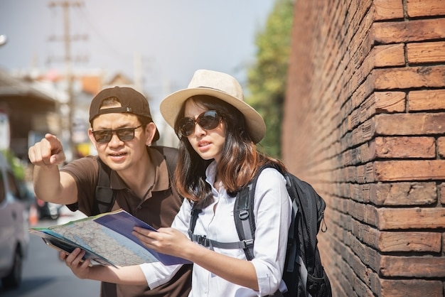Asian couple tourist holding city map 