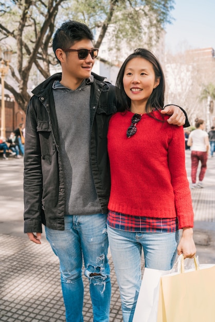 Free photo asian couple walking in the city.