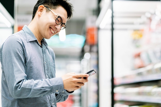 免费照片亚洲客户男性购物选择产品从货架上商店购物中心的背景