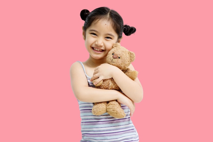 무료 Photo 분홍색 배경에 격리된 테디베어를 껴안고 있는 귀여운 아시아 소녀