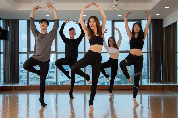 Asian dancers standing on one foot