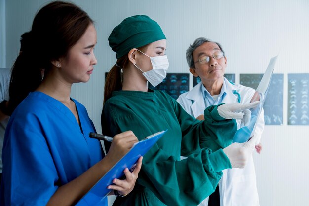 Free Photo asian doctor team examine xray film of patient analysis to find bext solution for operation and treat health ideas concept