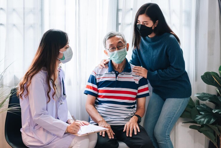 Asian doctor visit and examines a senior man at home The doctor checking up and consulting for retirement health partienthospital services and wearing a mask to protect covid19