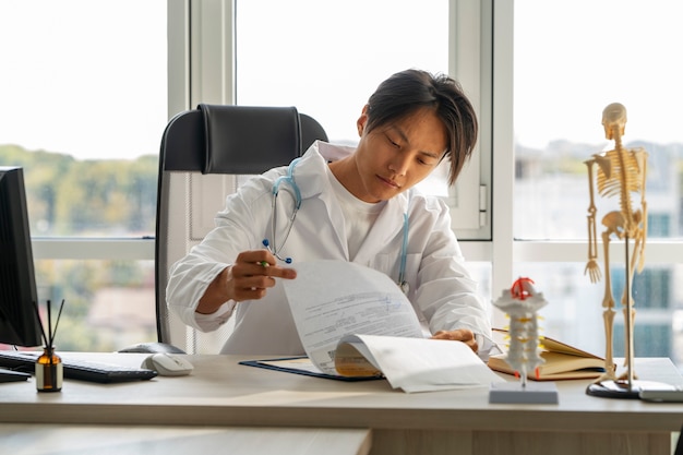 Foto gratuita colpo medio di lavoro del medico asiatico