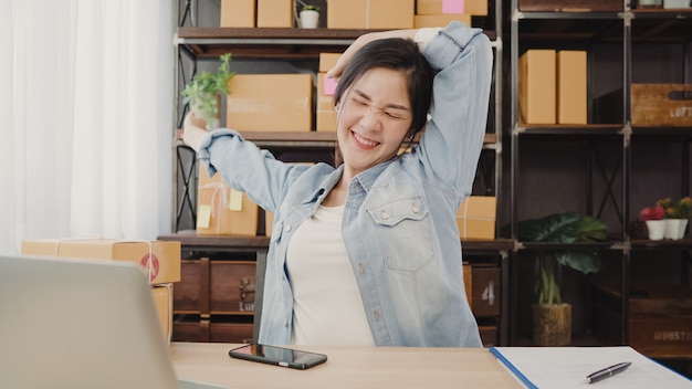 Asian entrepreneur business woman stretching her body after answer customer question