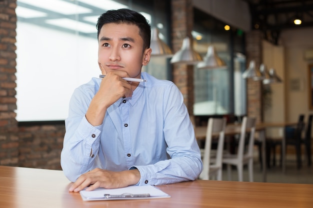 Азиатский Предприниматель мышления по проекту в кафе
