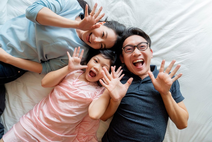 무료 Photo 아시아 가족 어머니 아버지와 딸이 거실에서 즐거운 수면 놀이를 하고 있습니다.