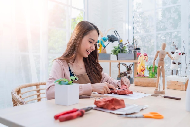 아시아 여성 예술가 arttoys 점토 조각은 그녀의 취미 점토 조각을 위해 주말 하루를 보내고 집에서 점토 조각상을 집에서 캐주얼한 생활 방식으로 만드는 동안 형태 얼굴 해부학을 적절하게 정의합니다.