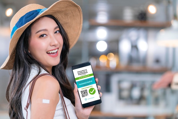 Free Photo asian female cheerful smiling teenager hand gesture point show vaccine brand against covid19 and digital vaccine passport from smartphone screen after getting vaccine prevent health concept