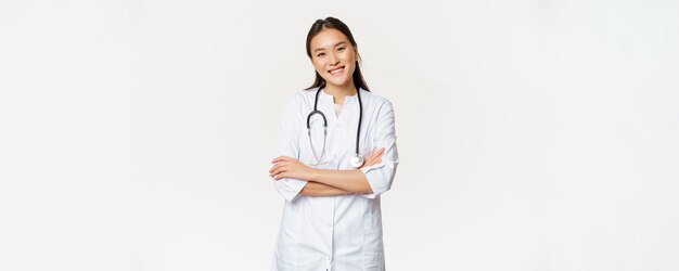 Asian female doctor physician in medical uniform with stethoscope cross arms on chest smiling and lo