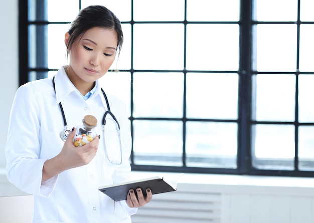 Free Photo asian female doctor, woman specialist with notebook and pills