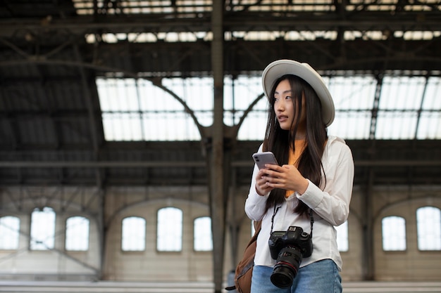 Foto gratuita viaggiatrice locale asiatica con una macchina fotografica