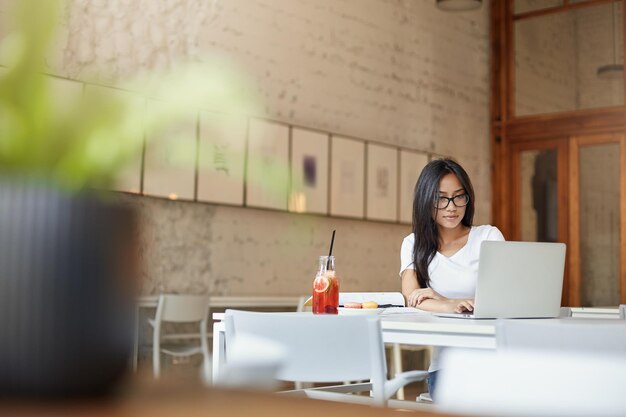 Азиатская женщина-стартап-предприниматель, работающая в кафе под открытым небом Широкий снимок негативного пространства Студентка учится в кампусе