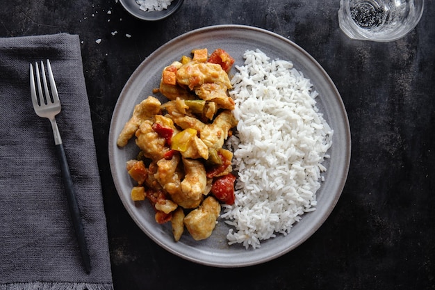 Курица азиатской кухни, обжаренная с соусом и рисом, подается на тарелке