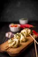 Foto gratuita alimento asiatico sul bordo di legno con aglio e le bacchette