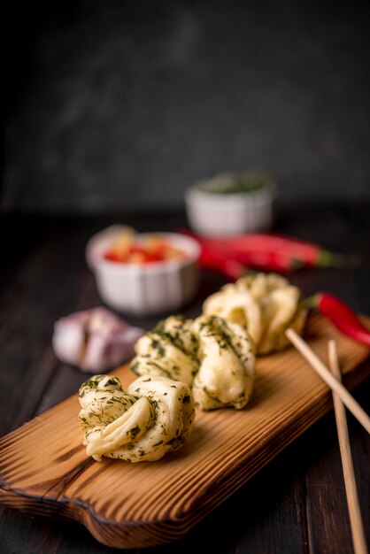 Asian food on wooden board with garlic and chopsticks