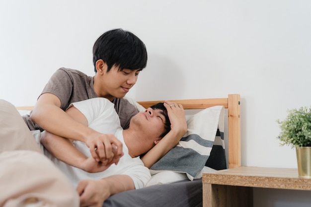 아시아 게이 커플 키스 하 고 집에서 침대에 포옹. 젊은 아시아 LGBTQ + 남성 행복 휴식 휴식 함께 아침에 집에서 침실에서 일어나 후 낭만적 인 시간을 보내십시오.
