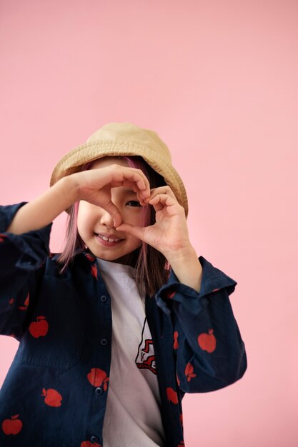 Asian girl doing a heart with her hands
