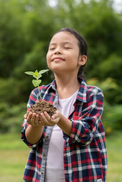 Asian girl holding plant and soil