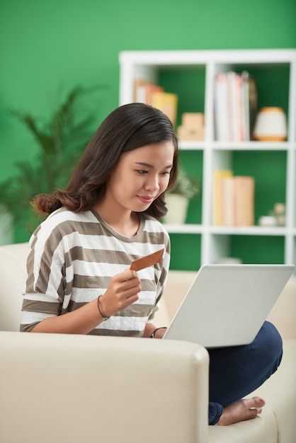 Asian girl making online orders on laptop