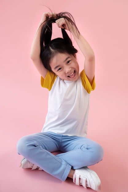 Ragazza asiatica che posa e che tira i suoi capelli