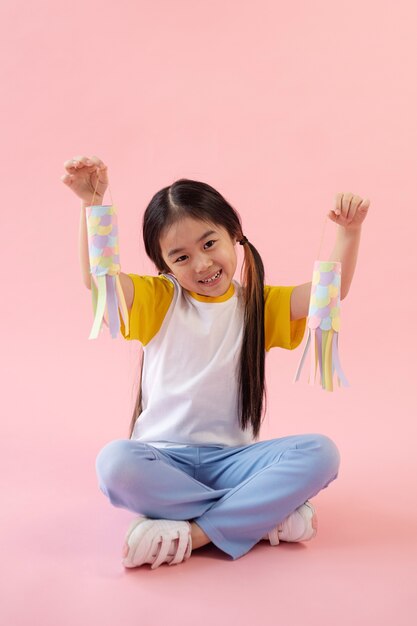 Asian girl showing paper fishes
