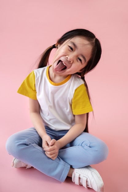 Foto gratuita ragazza asiatica che tira fuori la lingua