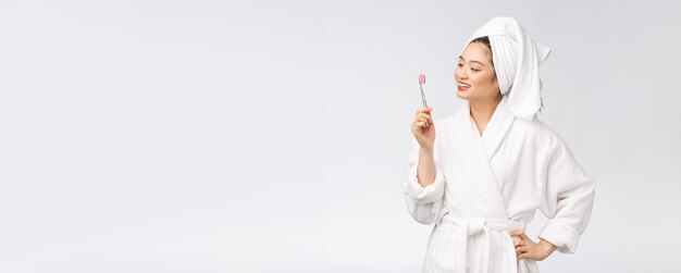 Азиатская счастливая женщина с зубной щеткой в халате утреннее настроение