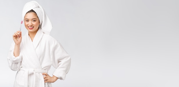 Asian happy woman with toothbrush in bathrobe morning mood