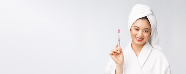 Asian happy woman with toothbrush in bathrobe morning mood