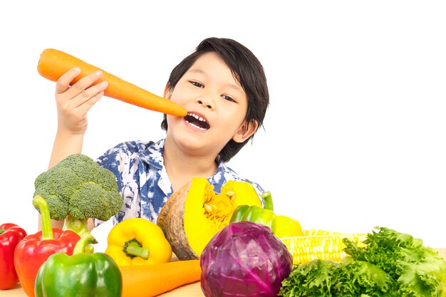 Азиатский здоровый мальчик показывая счастливое выражение с овощем разнообразия свежим красочным