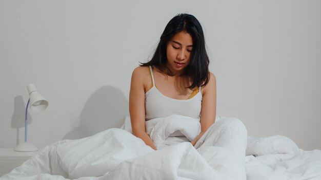 Asian indian lady sleep in room at home. Young Asian girl feeling happy relax rest lying on bed, feel comfortable and calm in bedroom at house at the morning.