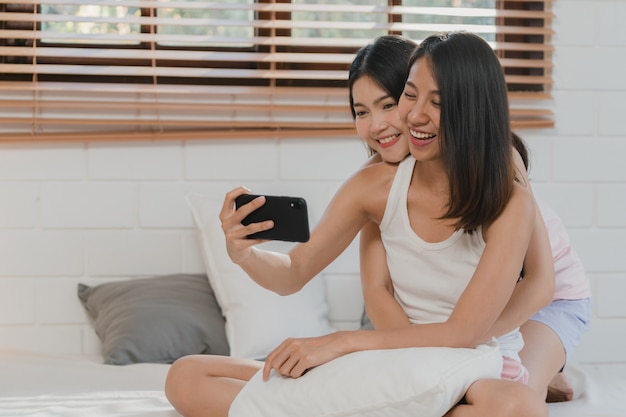 Free photo asian influencer lesbian lgbtq women couple vlog at home.