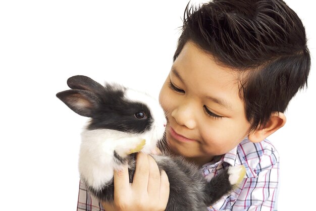 Азиатский малыш играет с прекрасным кроликом